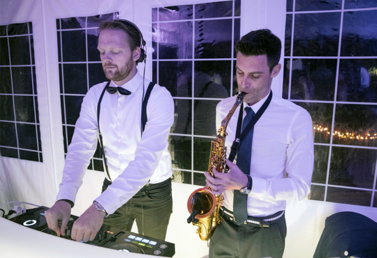 DJ met saxofonist tijdens een trouwfeest