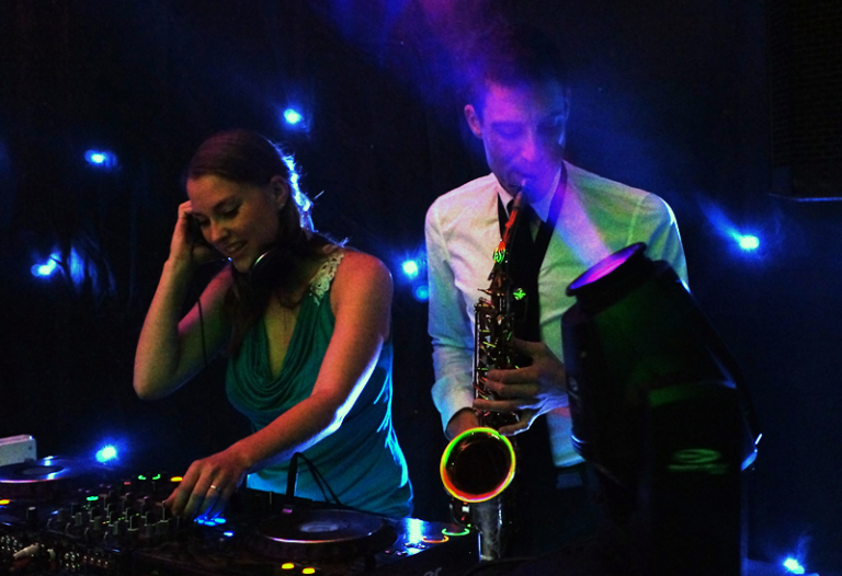 DJ en saxofonist spelen samen op een bruiloft